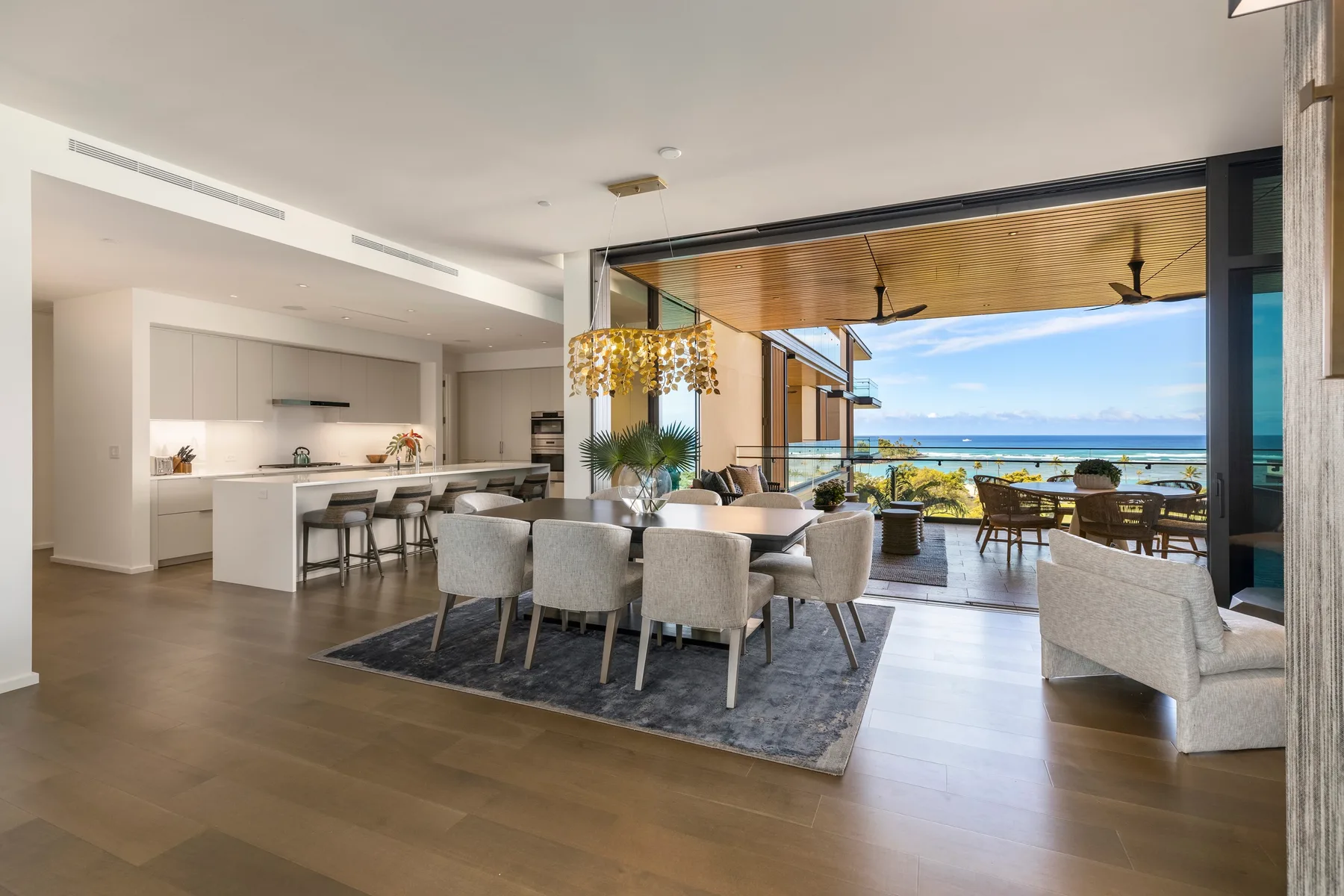 An open-plan dining and kitchen area opens onto a terrace overlooking the water.