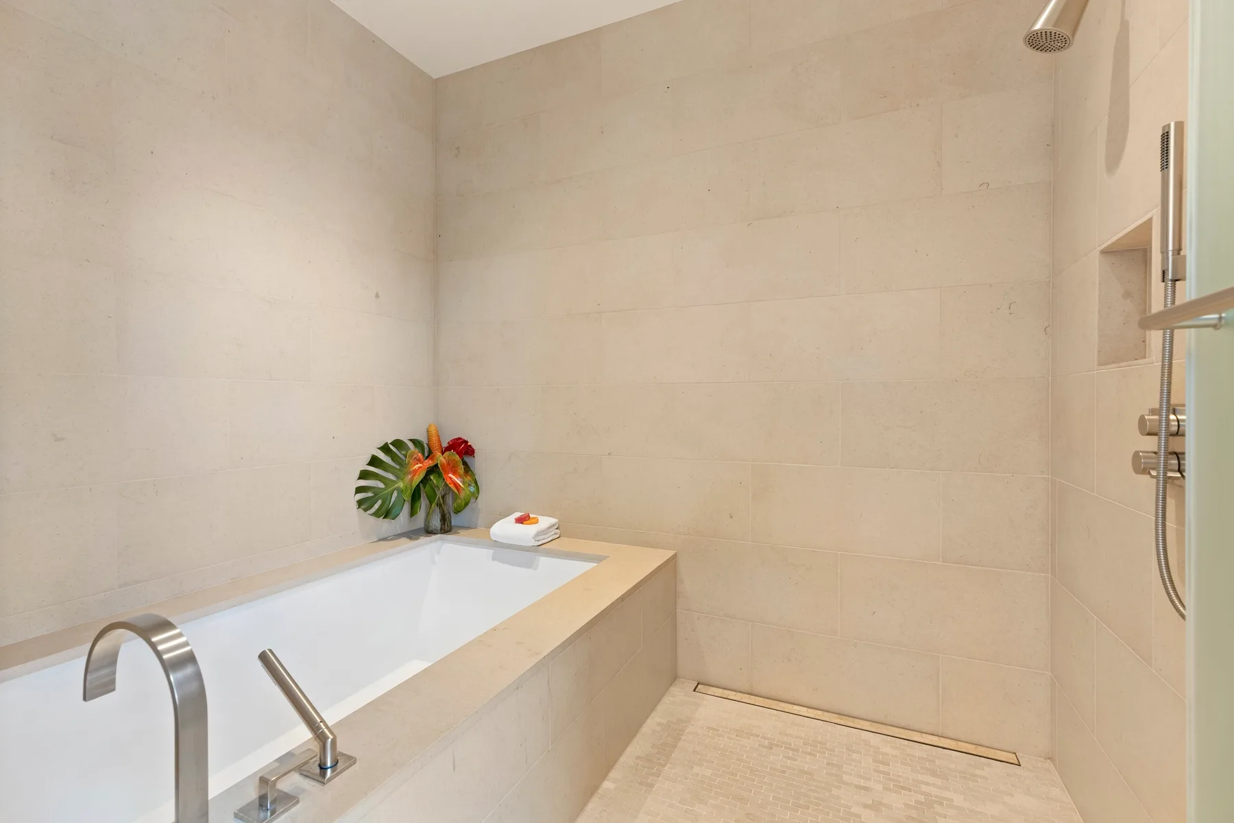A tiled bathroom with a built-in bathtub and shower.