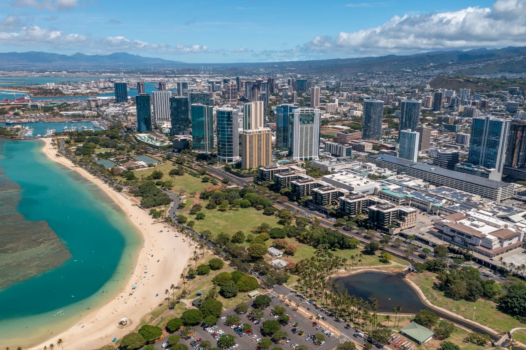 Aerial view of a coastal city with high-rise buildings beside a curved beach.