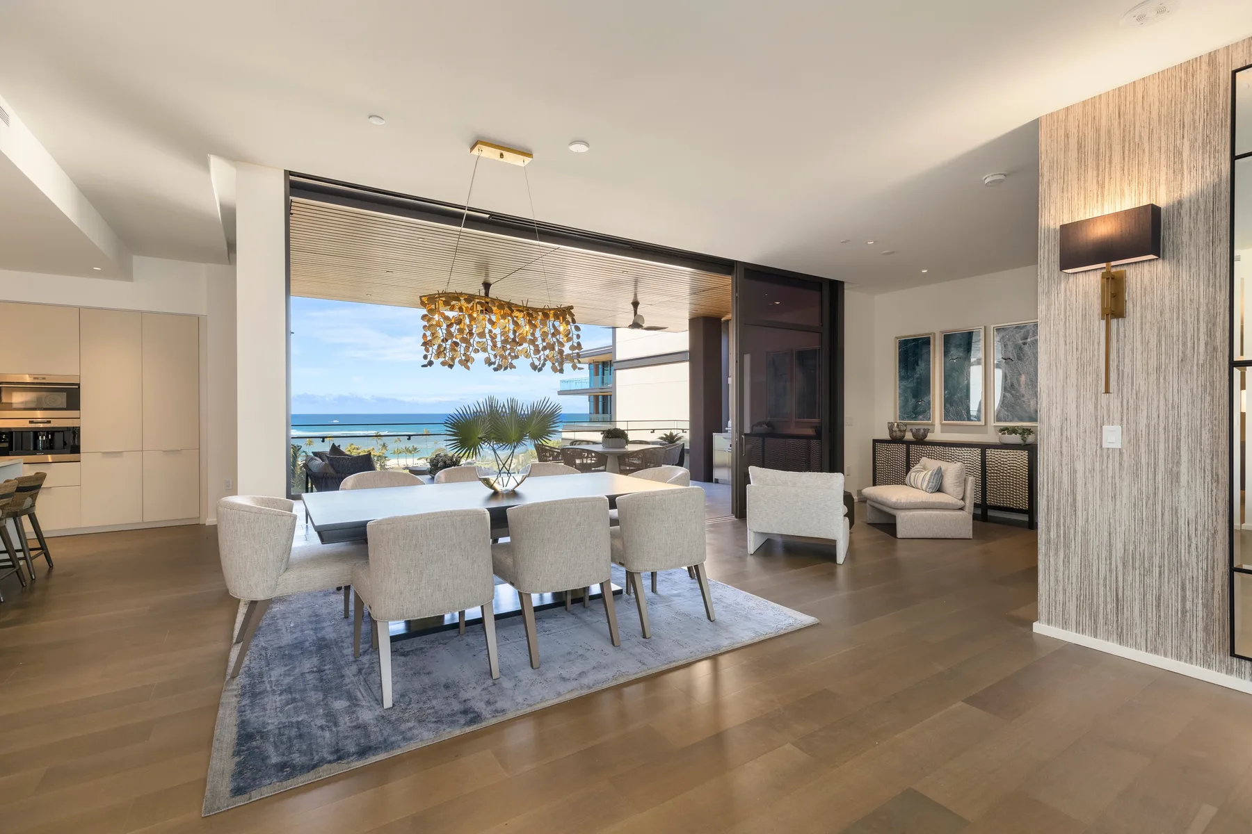 An open-plan dining and living area with large windows overlooking the water.