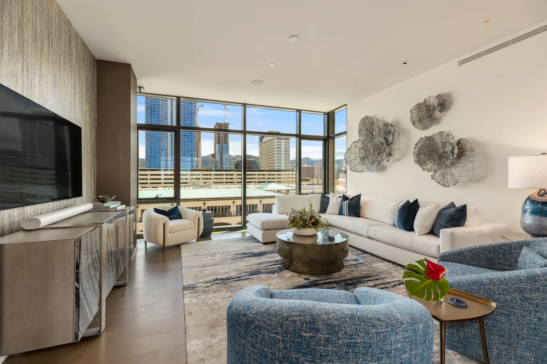 A bright living room with seating around a coffee table and large windows.