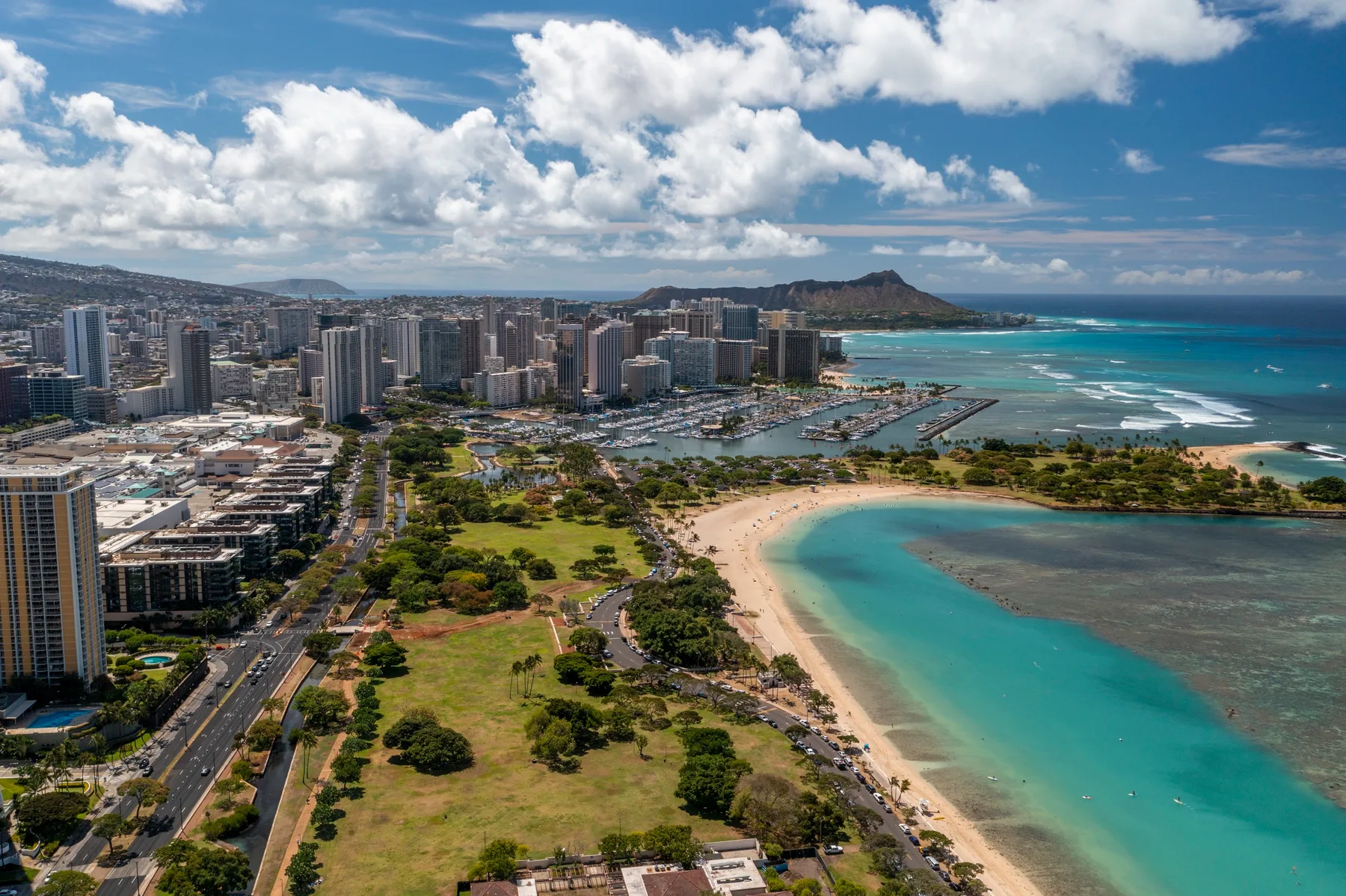 Aerial view of a coastal city with a sandy beach and turquoise water.