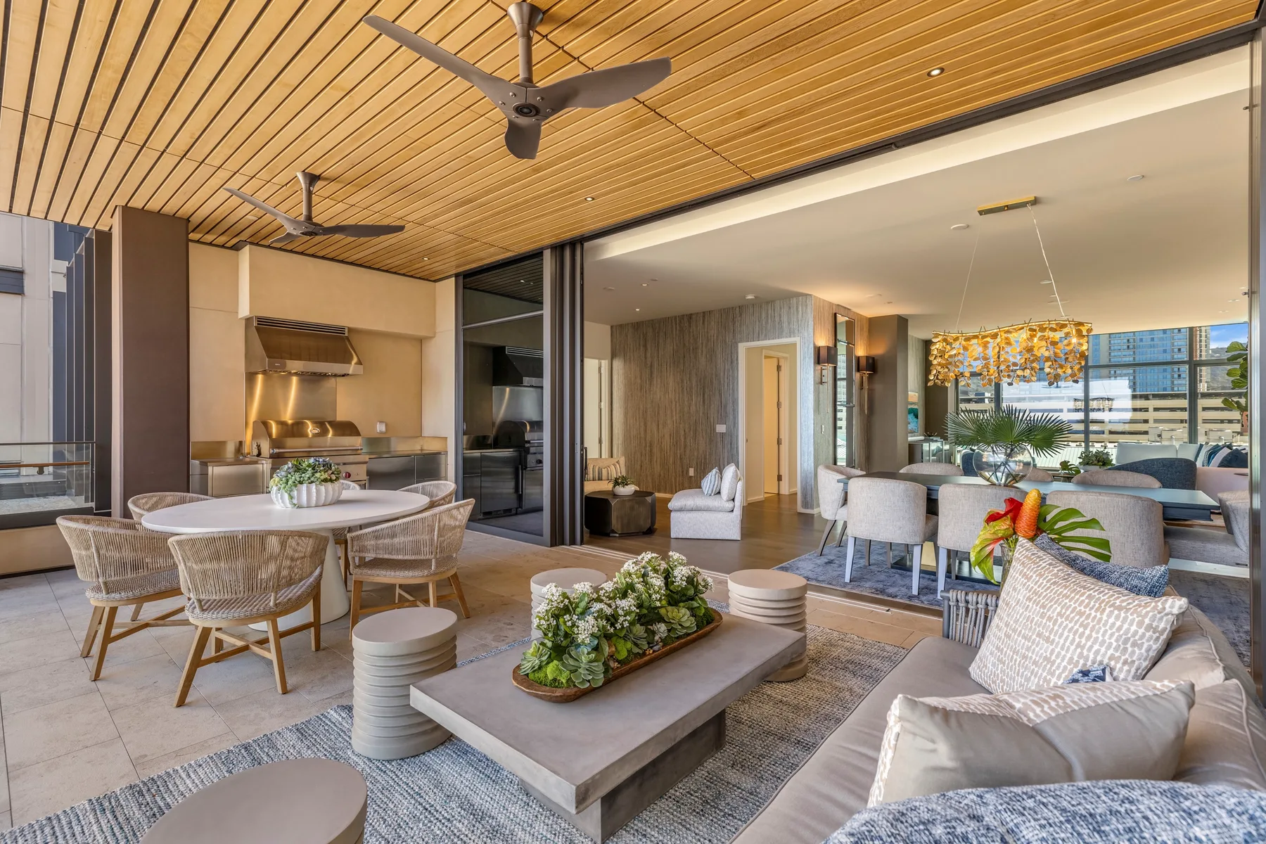 An open-plan living and dining area features a wood-slat ceiling and comfortable seating.