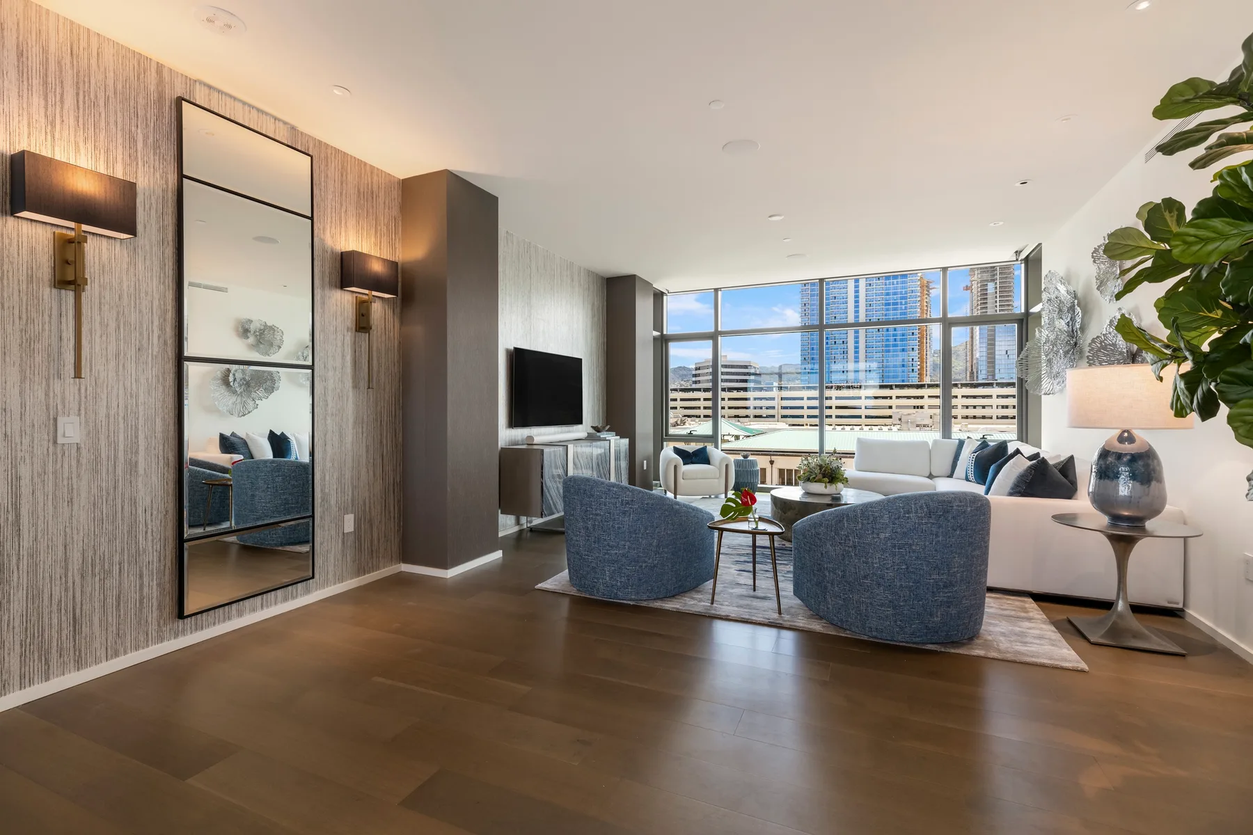 A bright living room with seating arranged around a coffee table beside large windows.