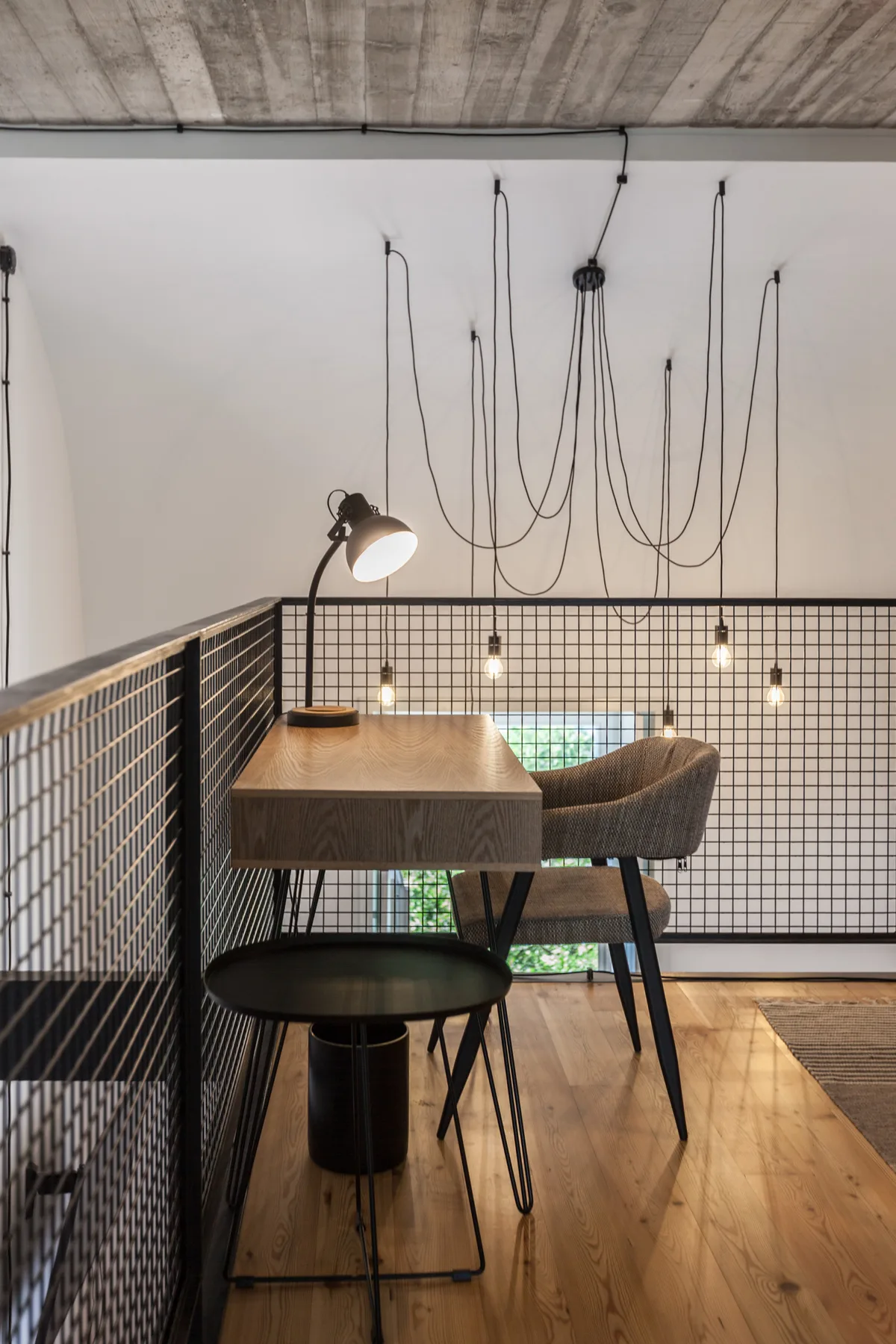 Una zona elevada de comedor con mesa de madera, asientos y lámparas colgantes.