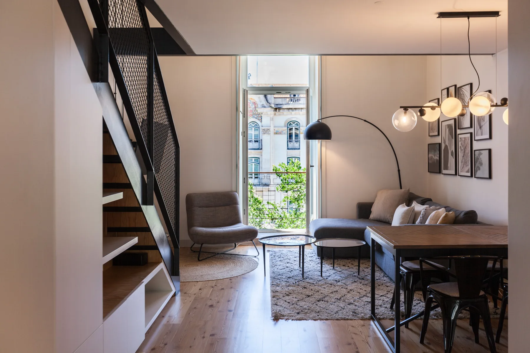 Una moderna sala de estar y comedor con asientos, una mesa y una ventana grande.