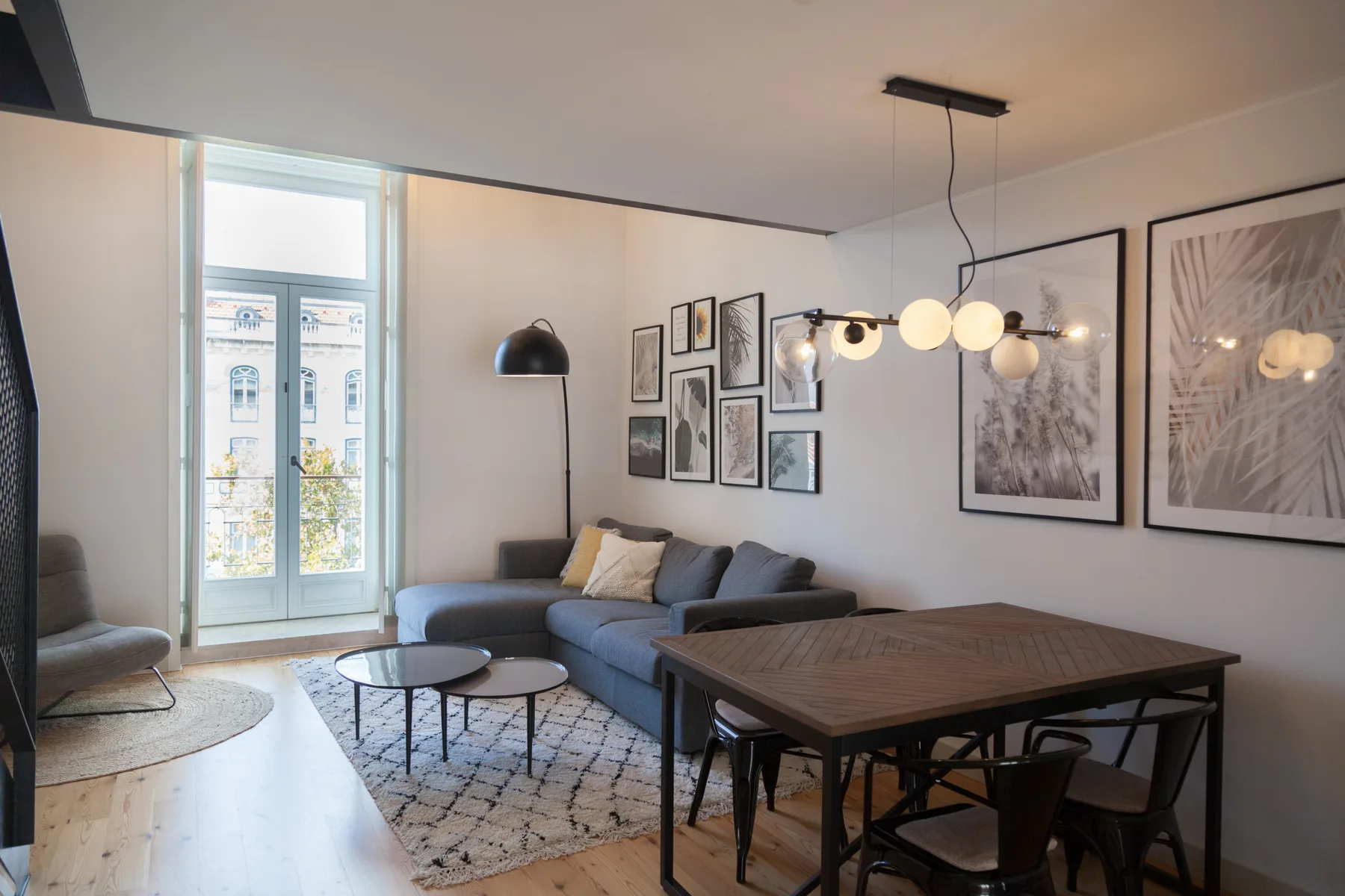 Una zona de estar y comedor con asientos, una mesa y cuadros enmarcados.