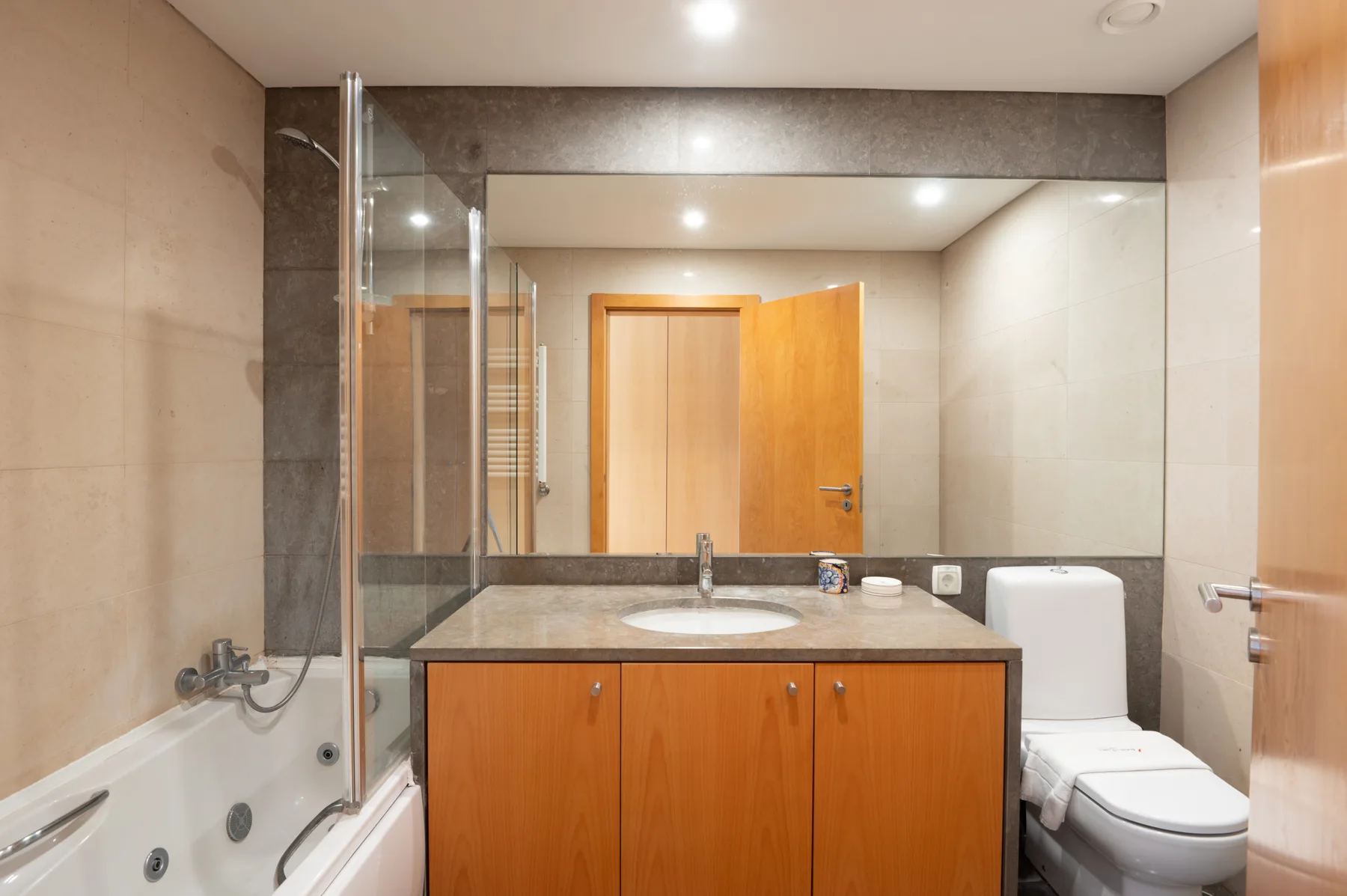 A tiled bathroom with a bathtub, sink, and toilet.