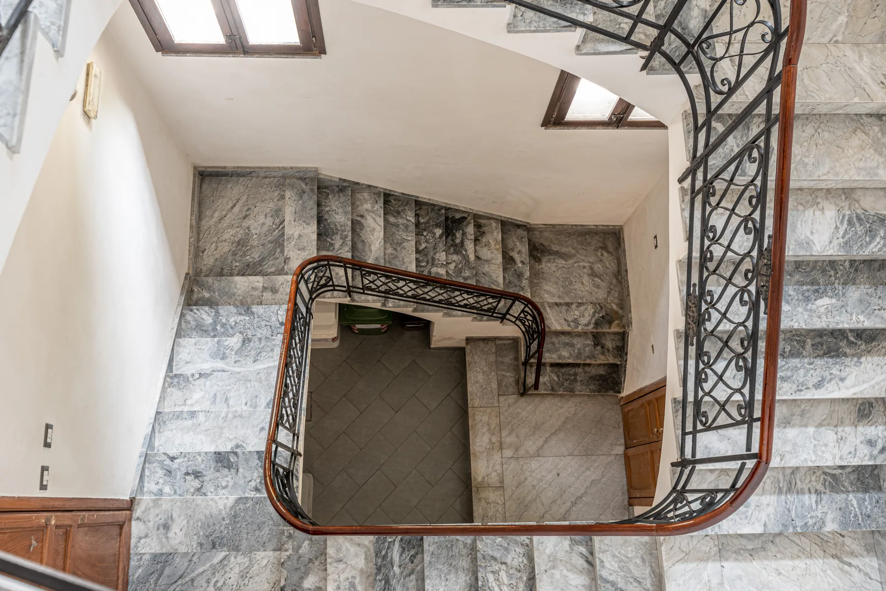 Una escalera con peldaños de piedra y barandillas de metal ornamentadas.