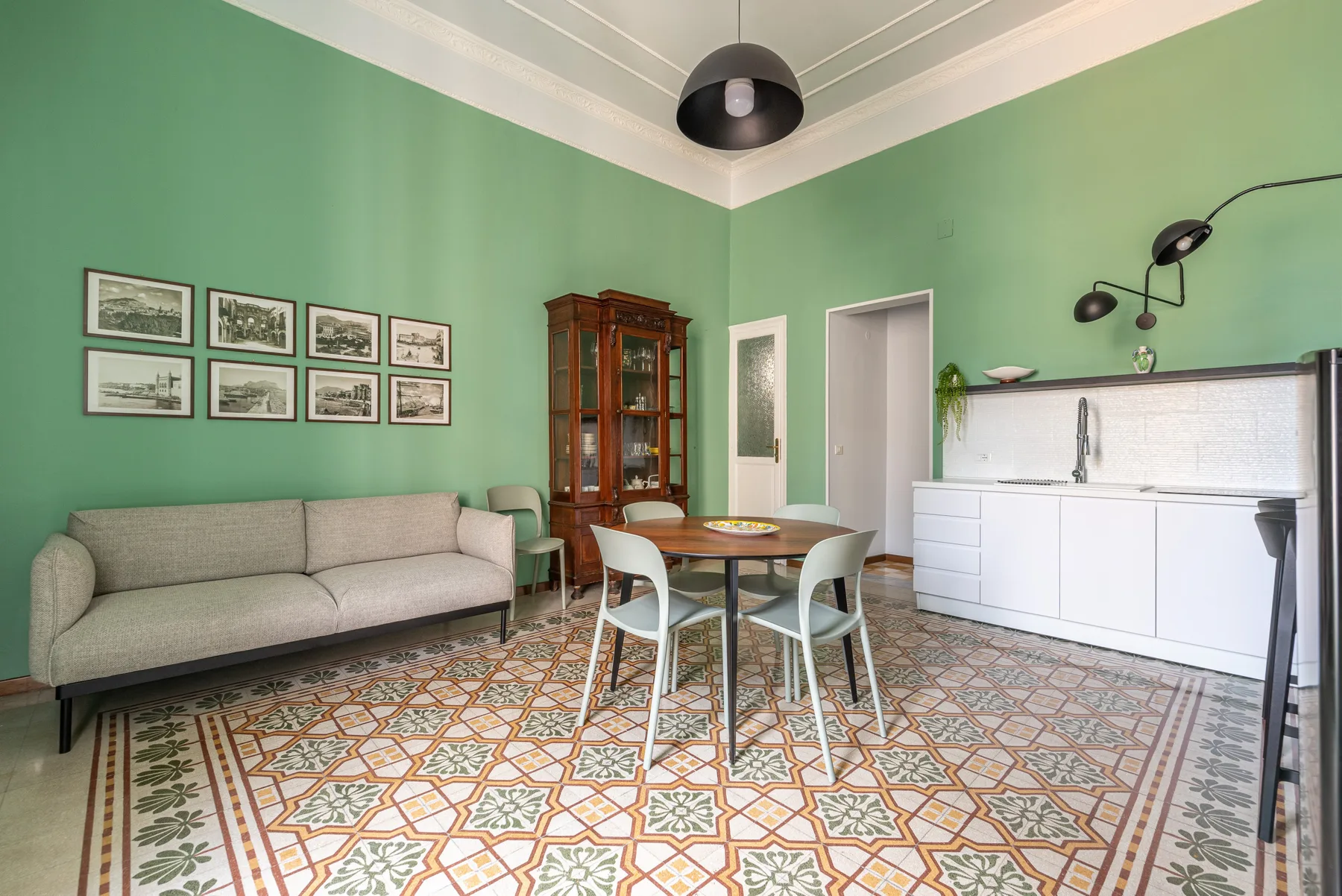 A dining area with a round table and seating beside a white kitchen counter.