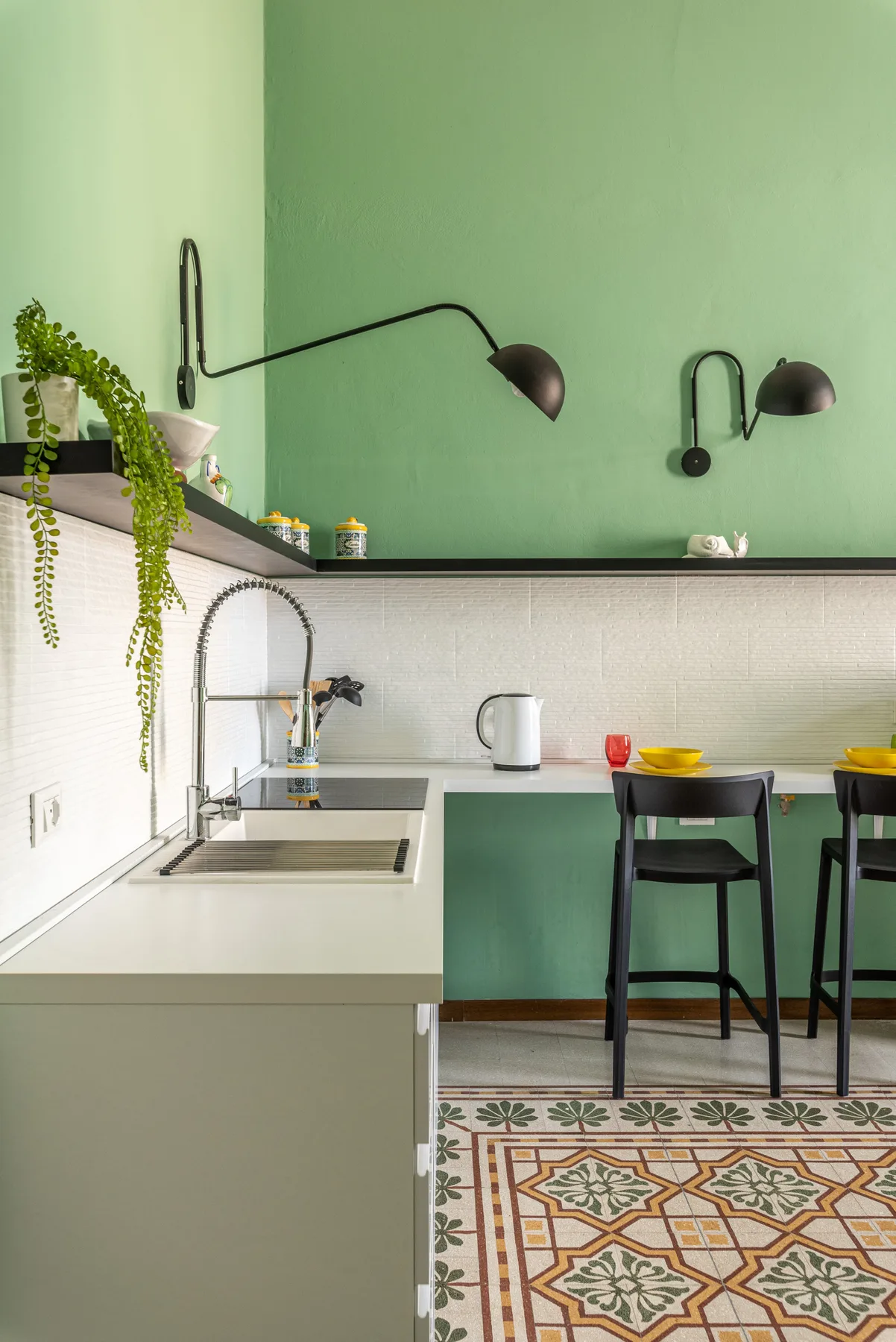 Una cocina moderna con fregadero, barra con asientos y suelo de baldosas estampadas.