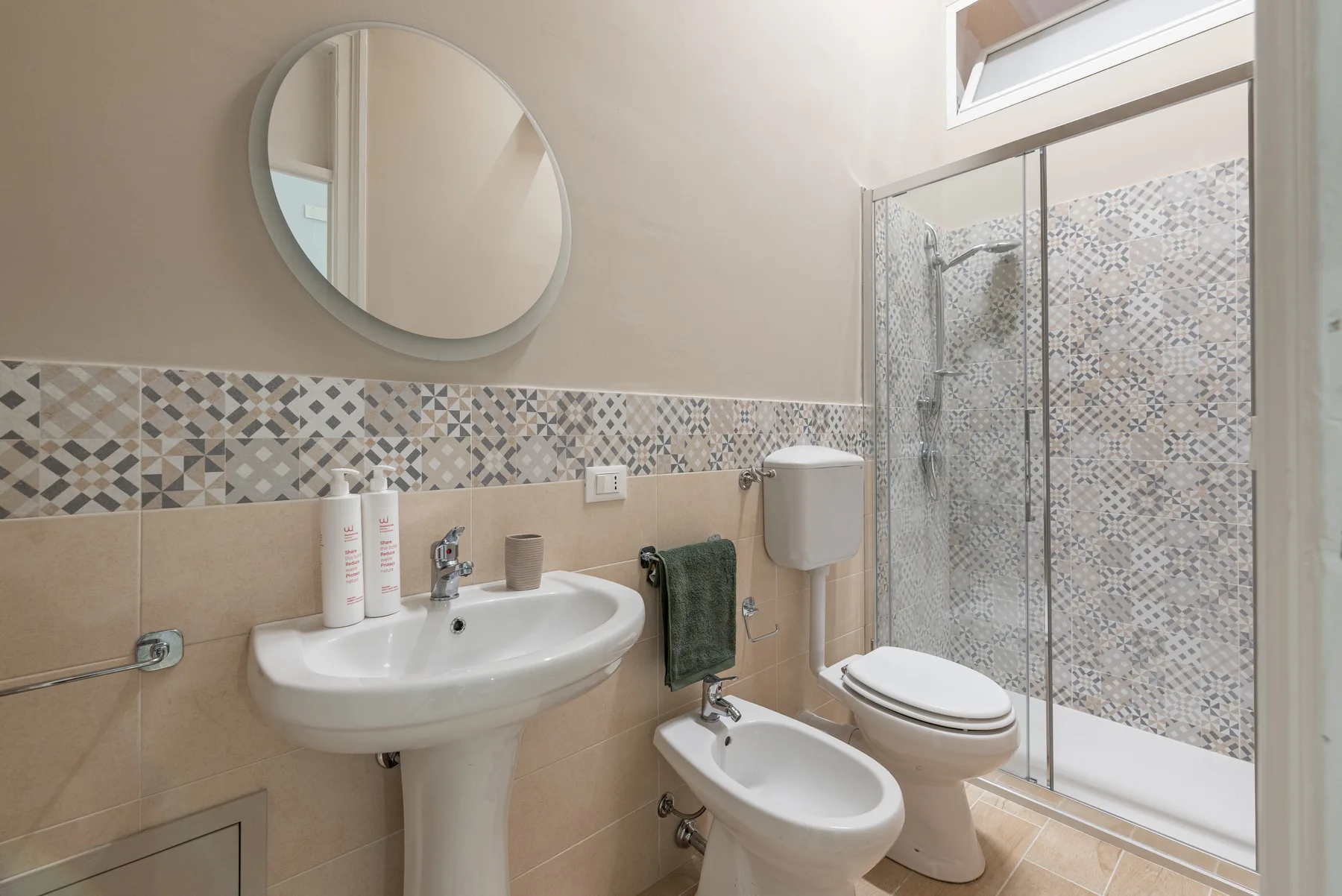 Un baño con lavabo, inodoro, bidé y ducha de vidrio.