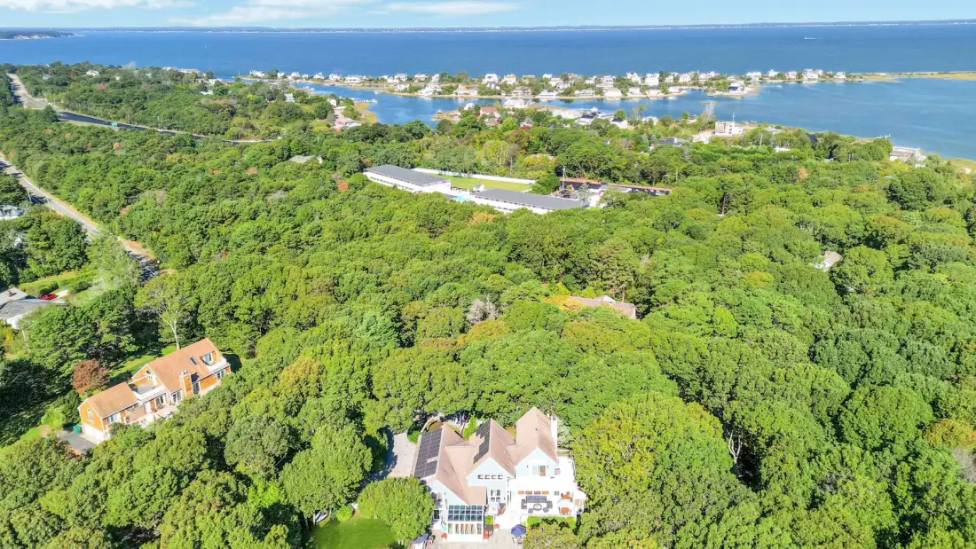 Una vista aérea muestra una casa rodeada de vegetación densa cerca de la costa.