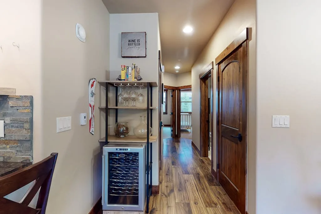 A hallway with wooden doors and a glass-front beverage cooler.