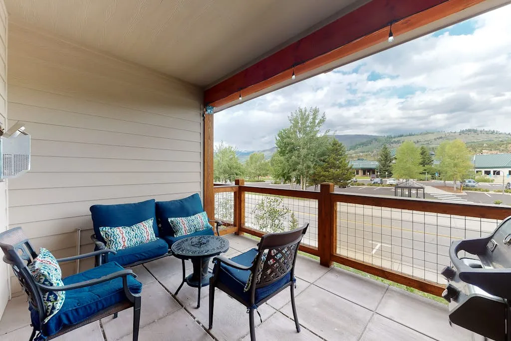 A covered outdoor seating area overlooks trees and distant hills.