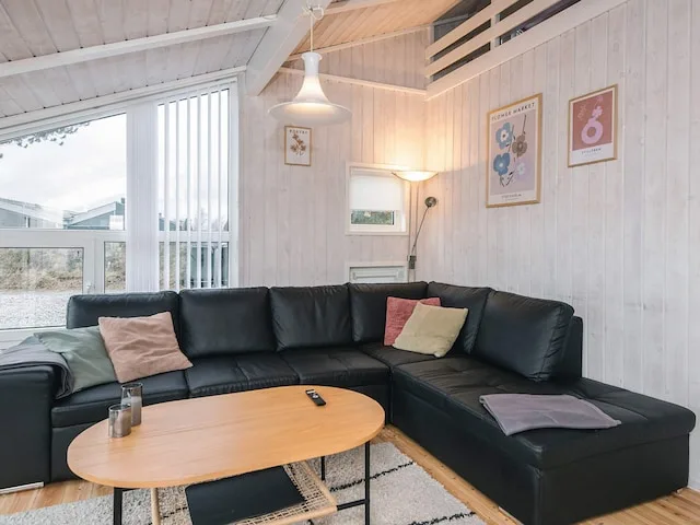 A bright living room with sectional seating and a low wooden coffee table.