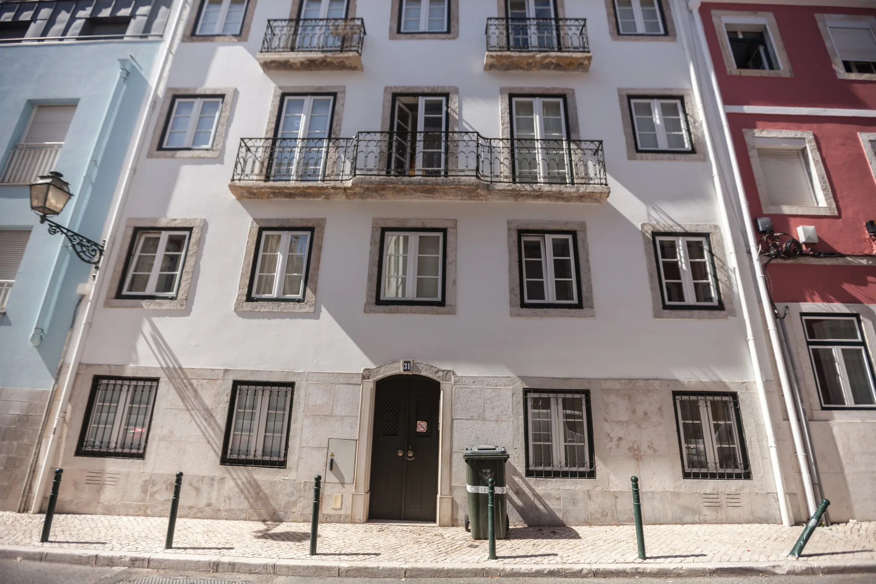 Fachada de un edificio de varias plantas con ventanas, balcones y una entrada central.