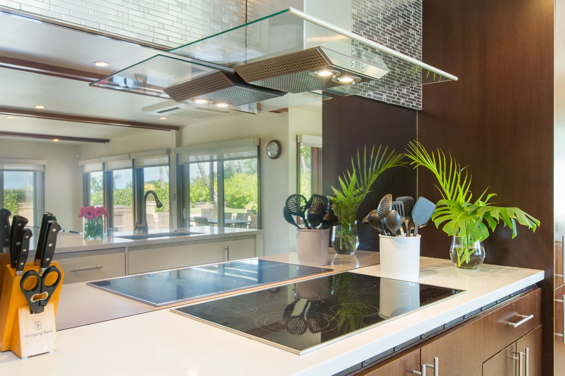 Una cocina moderna con una placa de cocción bajo una campana de vidrio.