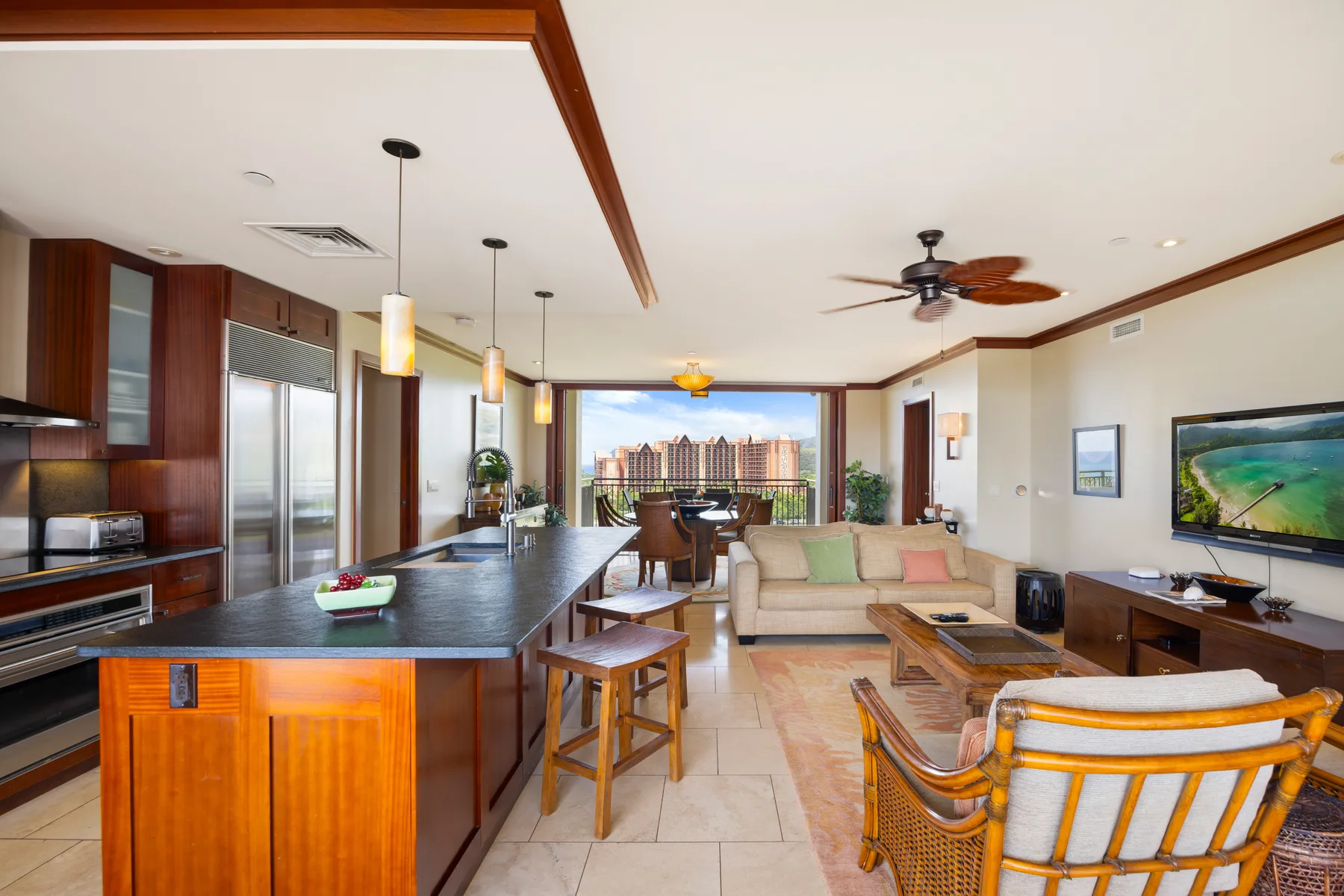 Sala de estar y cocina de concepto abierto, con comedor y ventanales.