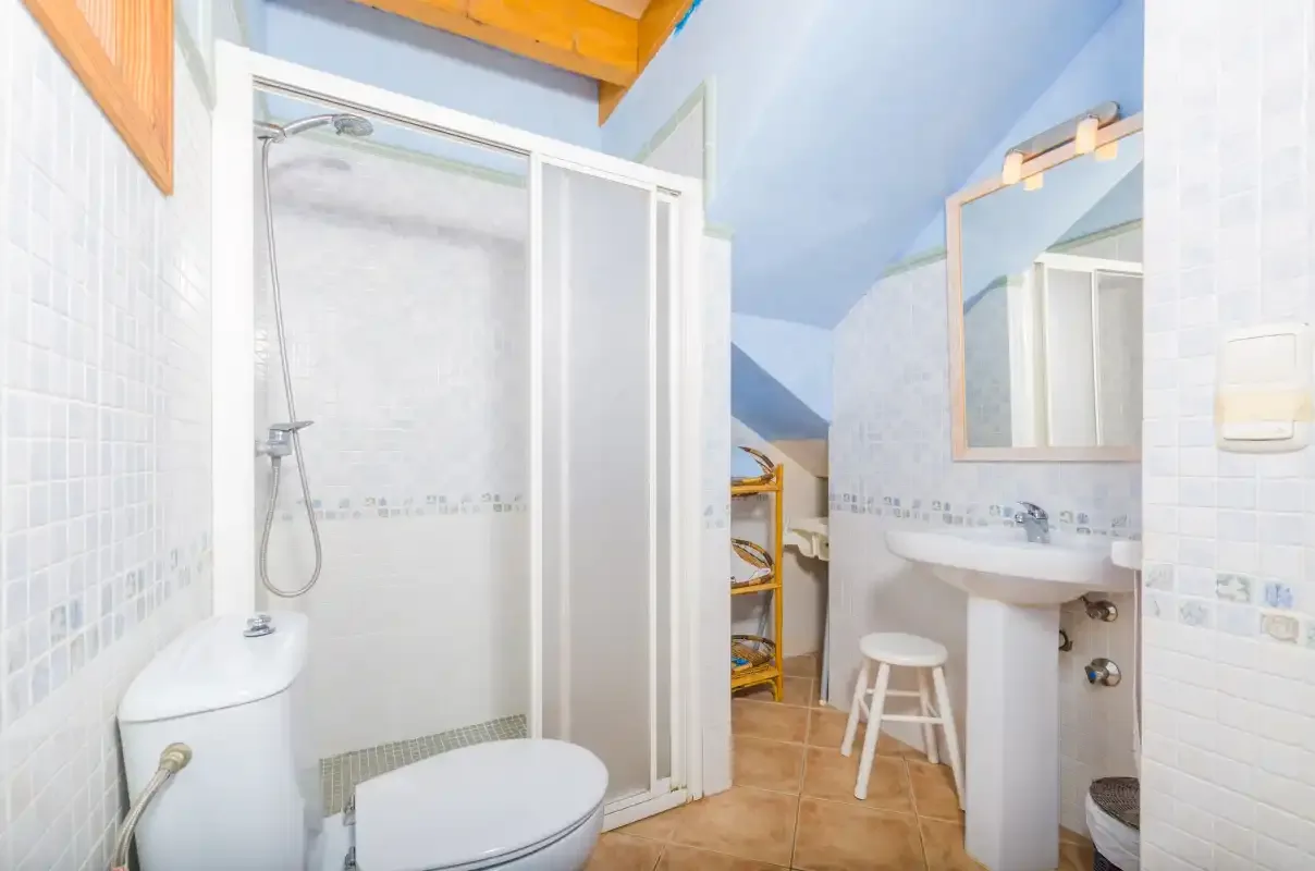 Un baño con ducha, inodoro y lavabo.