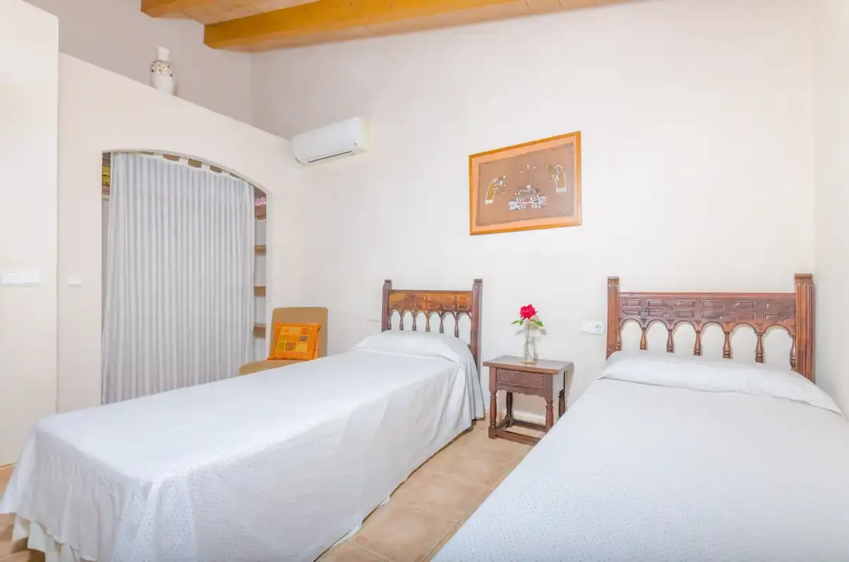 Un dormitorio con dos camas, una mesita de noche y un cuadro enmarcado.