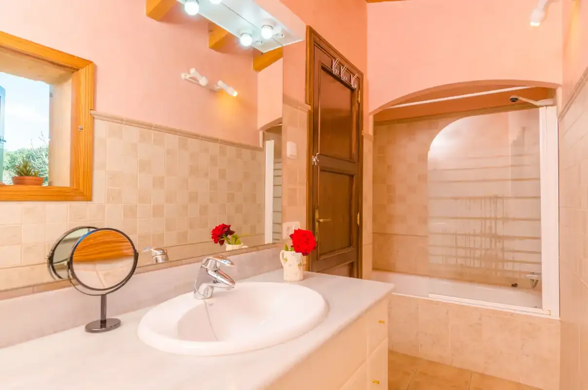 Un lavabo de baño está junto a una zona de ducha con azulejos.