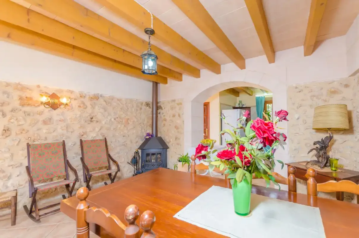 Un comedor con una mesa de madera y un jarrón de flores.