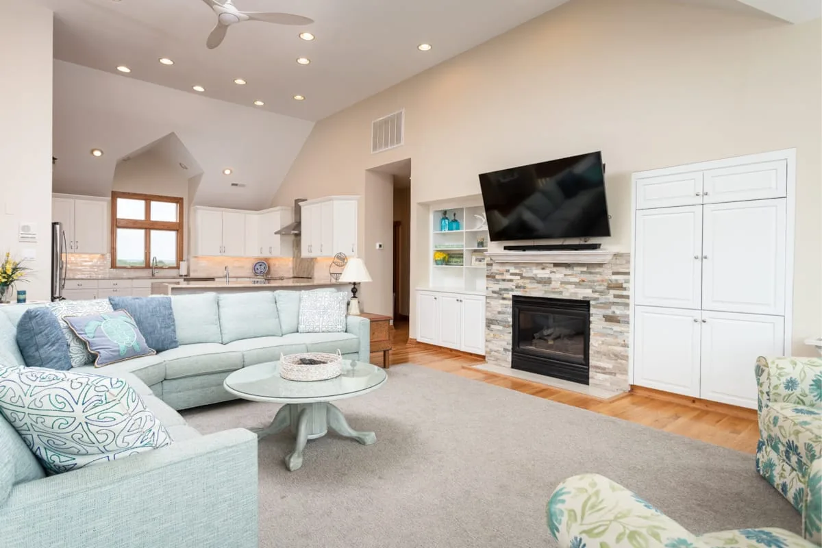 Living room with a sectional seating area, fireplace, and television.