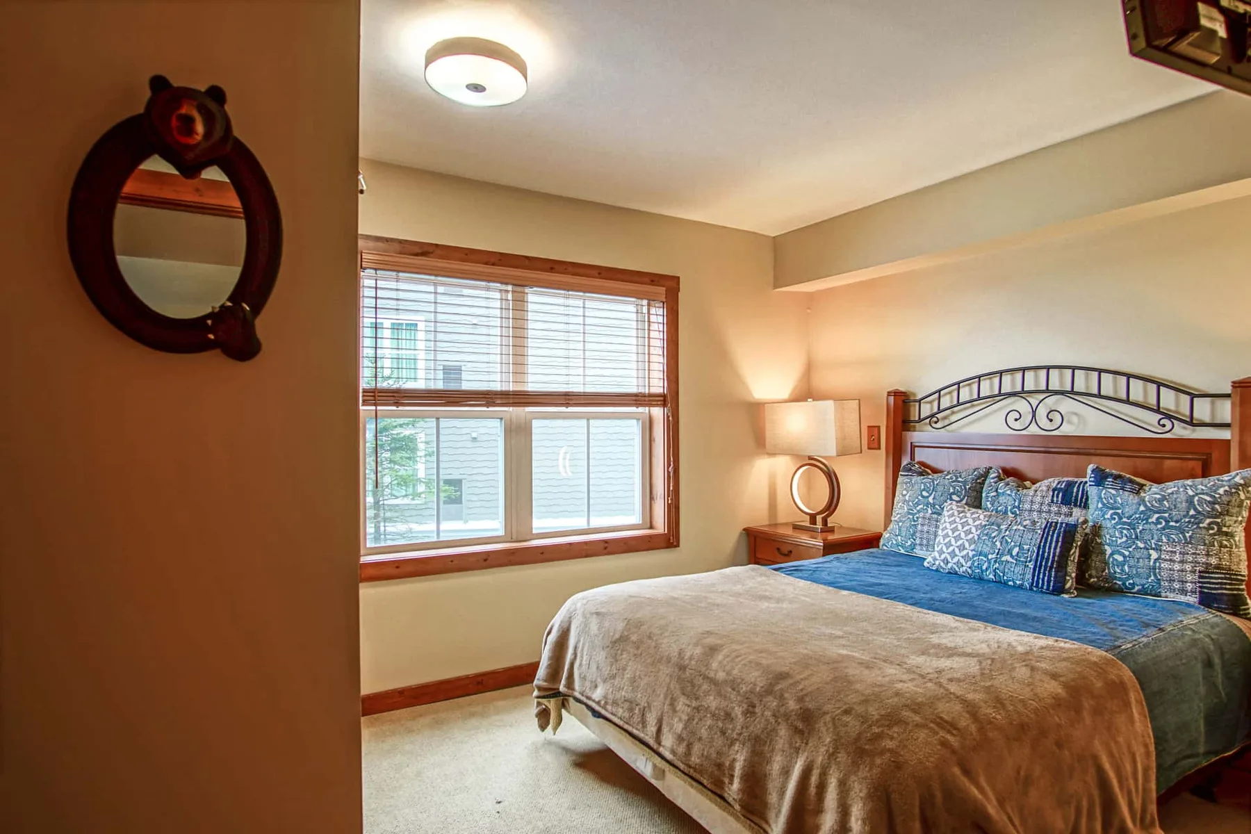 A bedroom with a bed beside a large window.