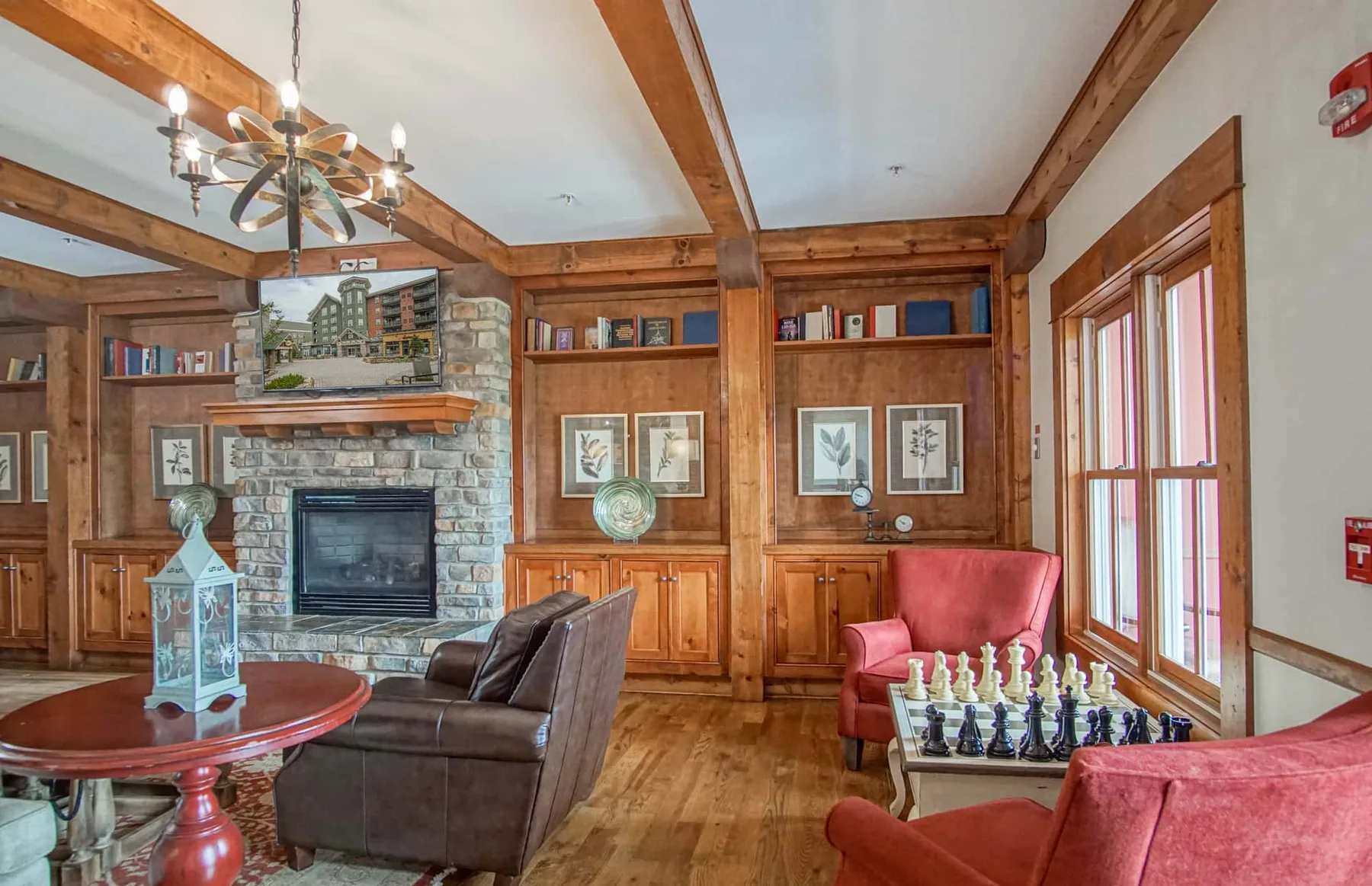 A wood-paneled living room with a stone fireplace and seating.