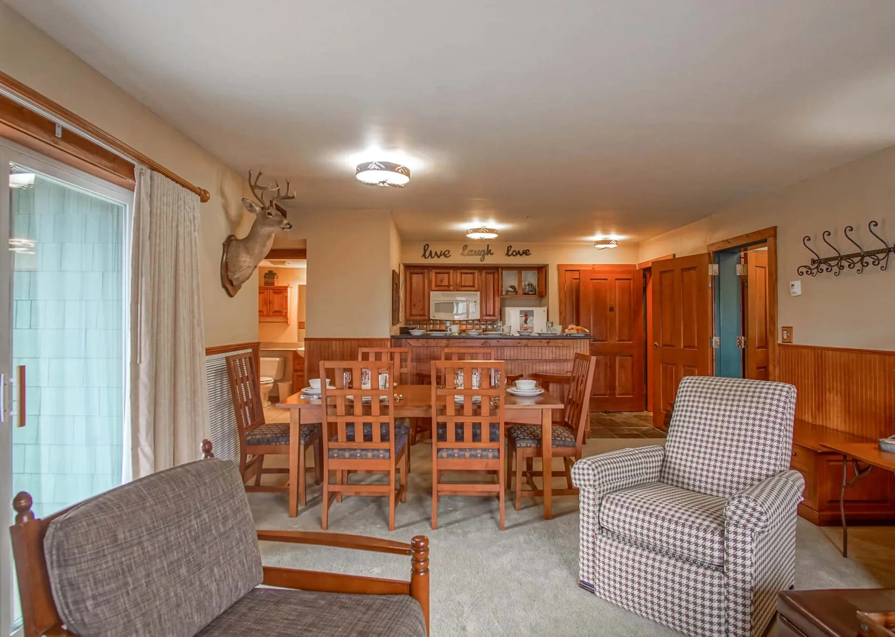 A dining and sitting area with a wooden table and upholstered seating.