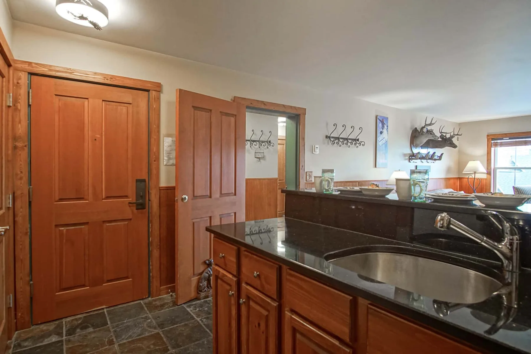 A bathroom vanity with a sink, wooden cabinetry, and a large mirror.