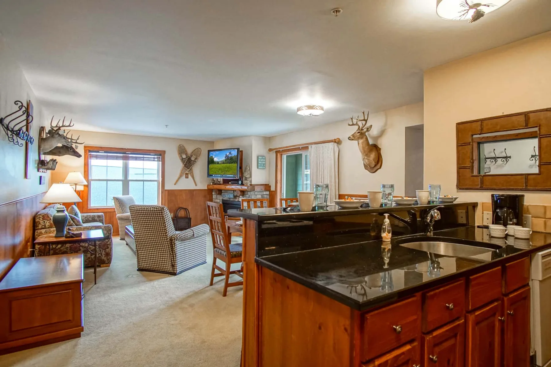 A combined kitchen and living area with a central island and seating by the window.