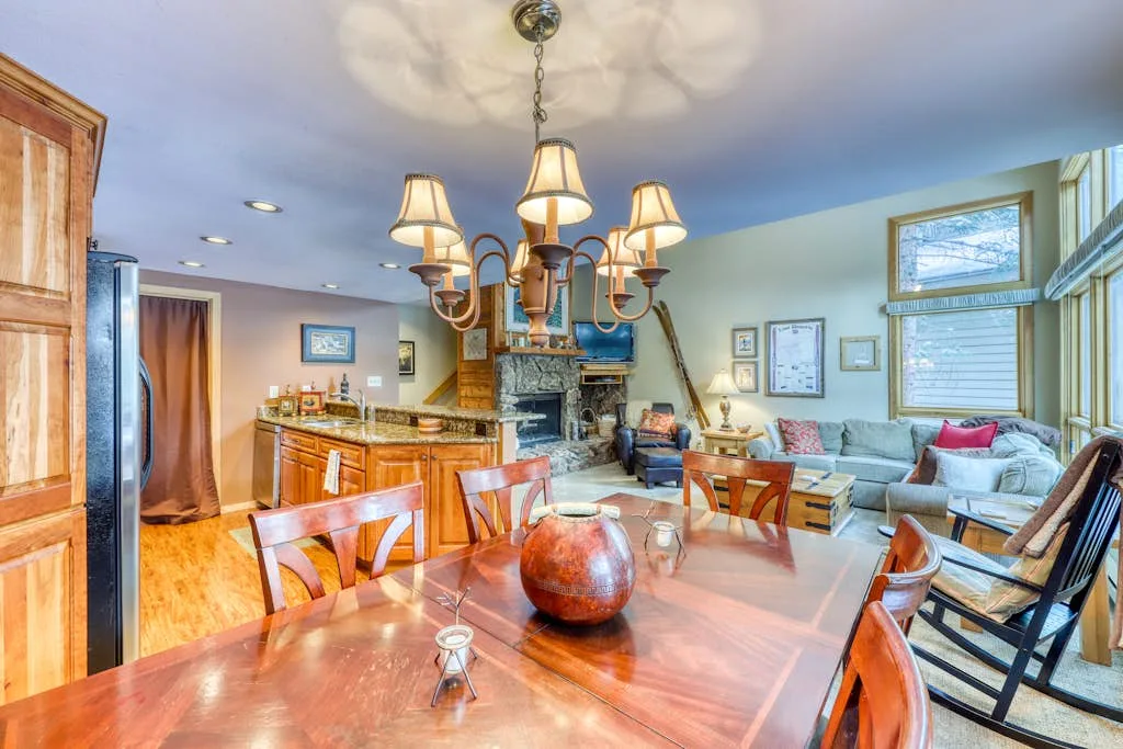 An open-plan dining and living area with a wooden dining table and seating.