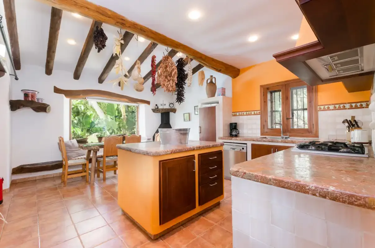 A spacious kitchen with a central island and a small dining area by the window.