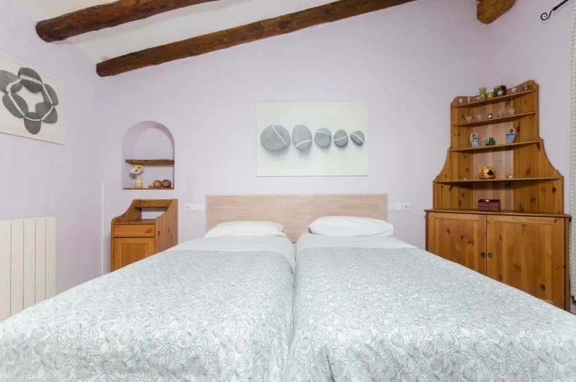 A bedroom with two beds and wooden furnishings.