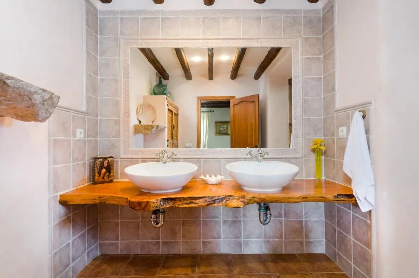 A bathroom vanity with two sinks sits beneath a wide mirror.