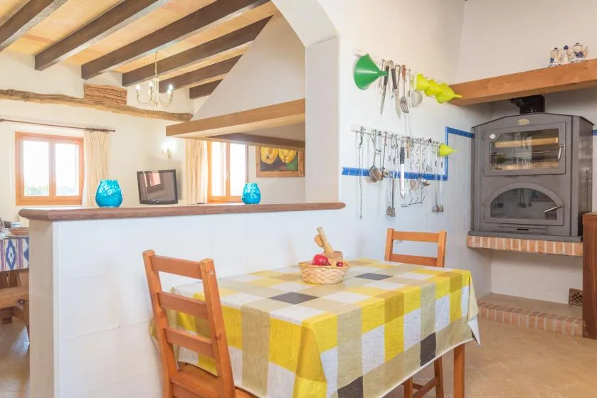 A dining area with a checkered tablecloth and a built-in oven.