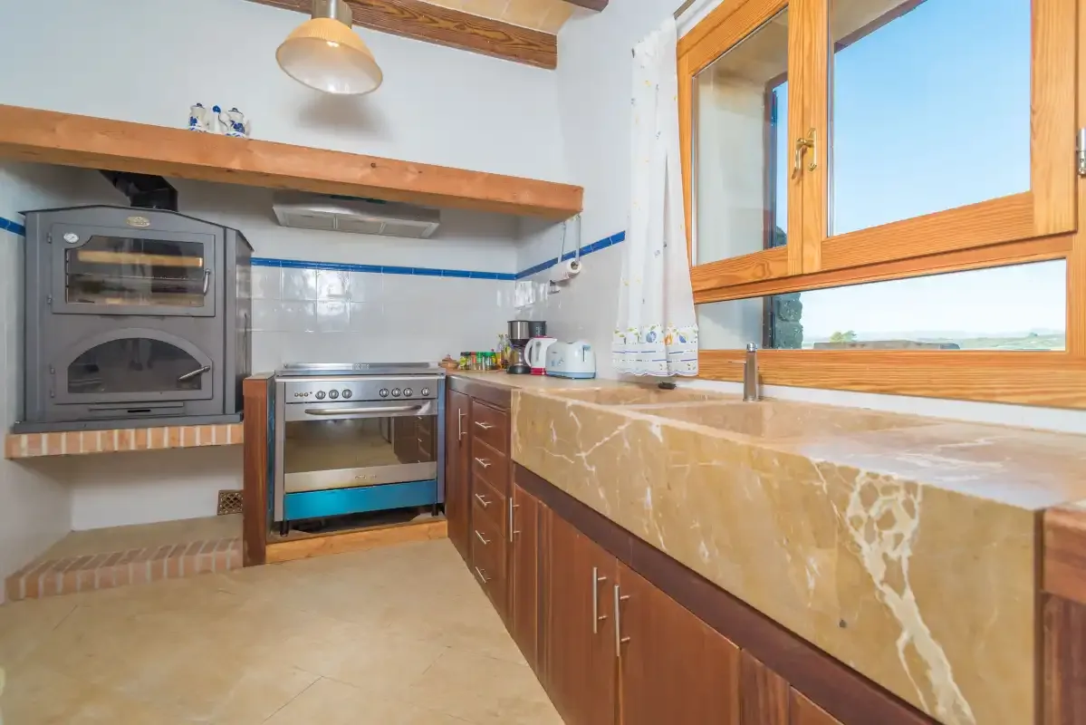A kitchen with wood cabinets, a countertop, and cooking appliances.