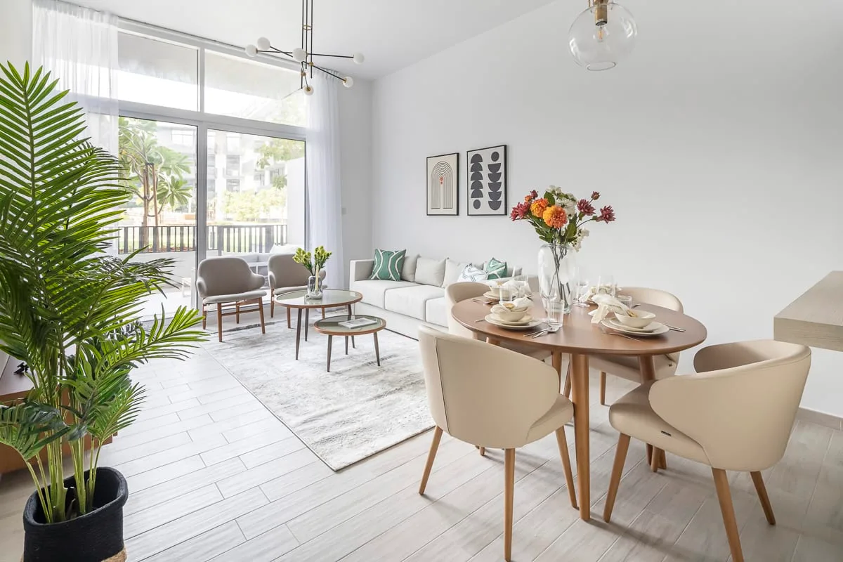 Una luminosa sala de estar y comedor con una mesa puesta junto a una zona de asientos.