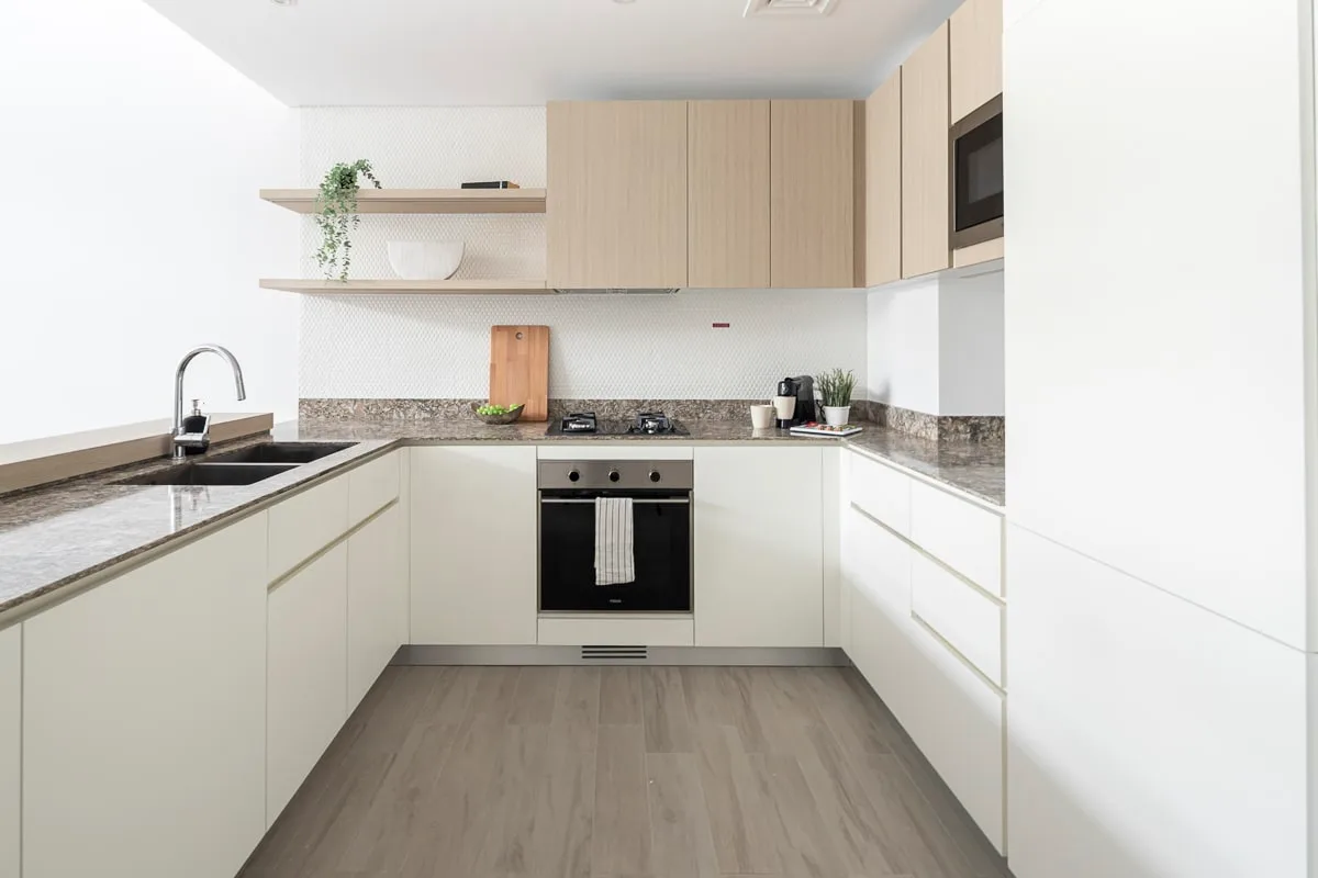 Una cocina moderna con gabinetes claros, una estufa y un fregadero.