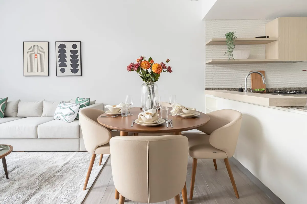 Un comedor con la mesa puesta junto a una zona de estar.