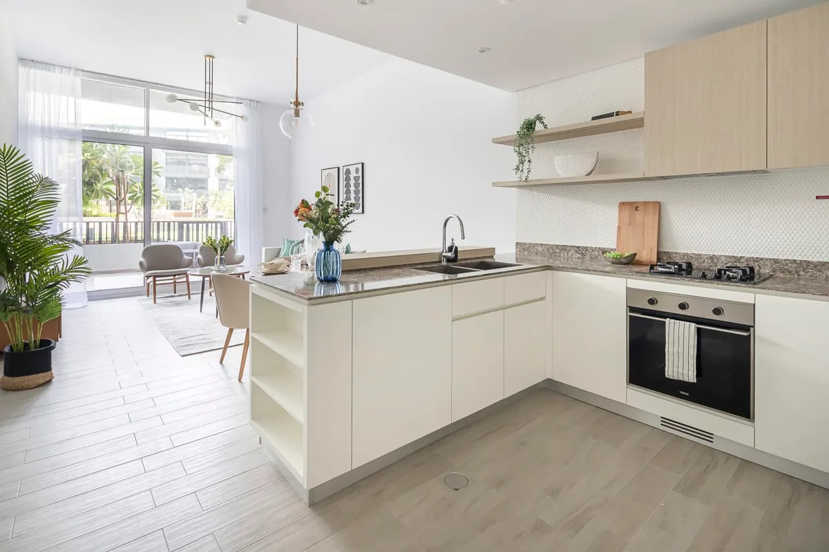 Una cocina luminosa y abierta, con una isla central y zona de comedor.