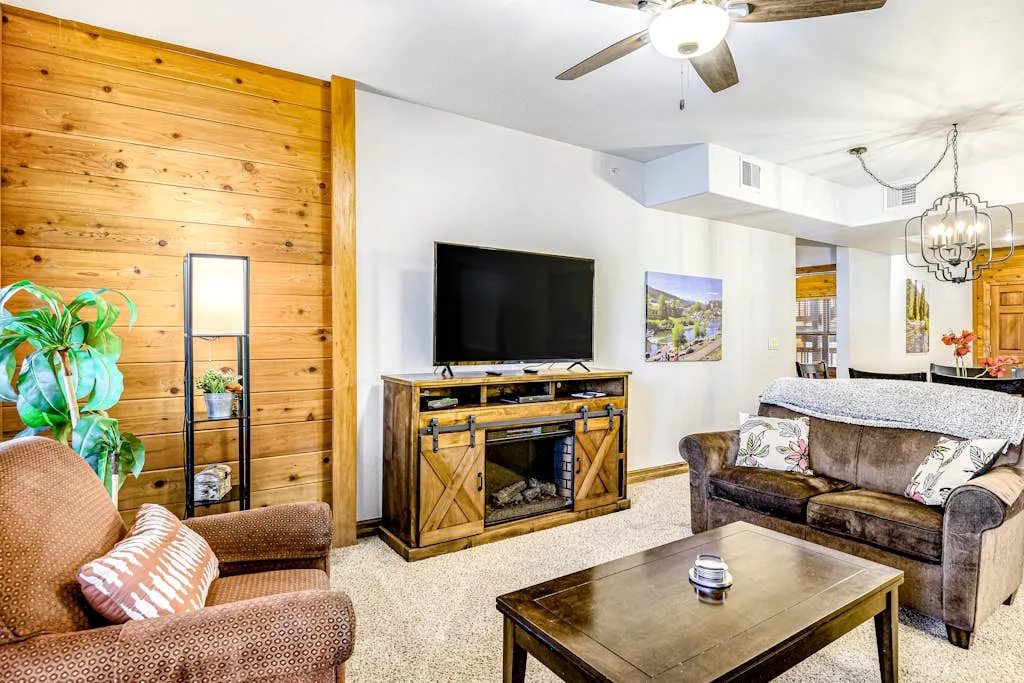 A living room with seating, a television, and a wooden coffee table.