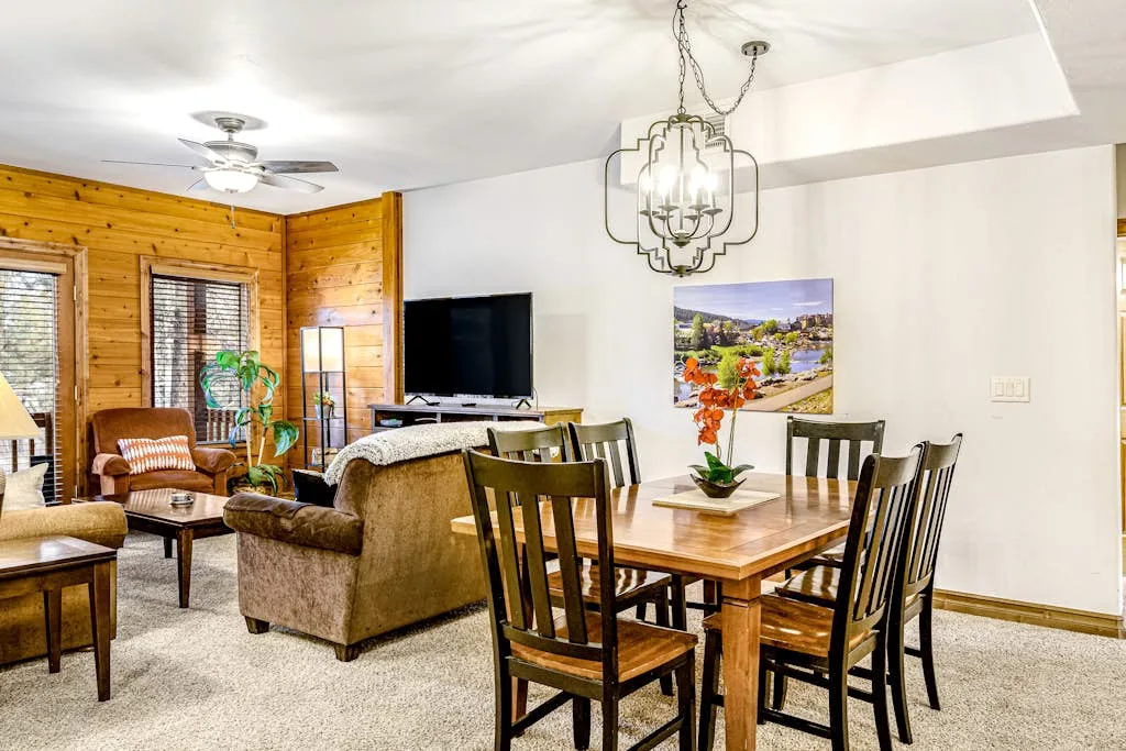 A living and dining area with wood seating and a television.
