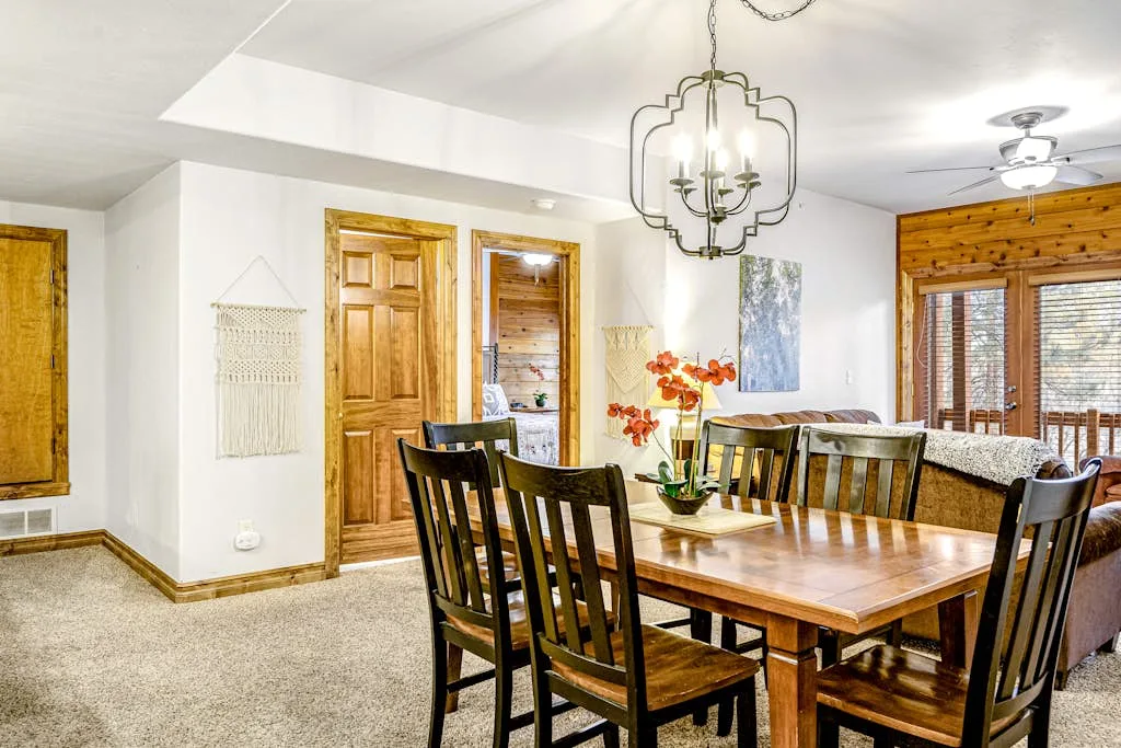Un comedor con una mesa de madera y sillas junto a un sofá.