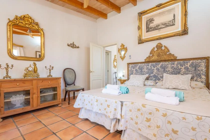 Un dormitorio con una cama grande, muebles de madera y vigas expuestas en el techo.