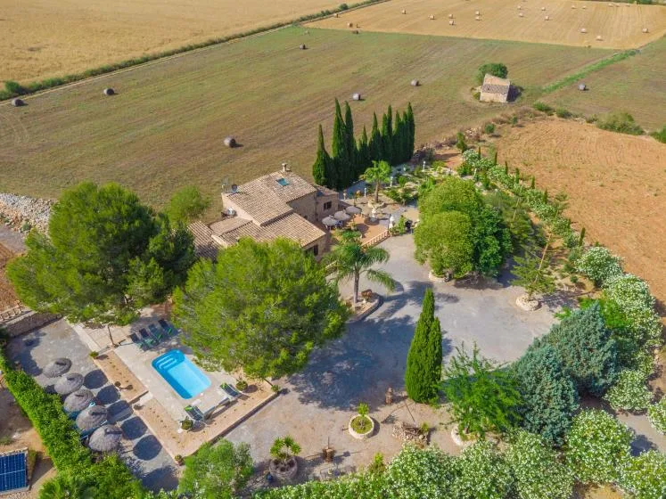Vista aérea de una propiedad rural con piscina junto a campos abiertos.