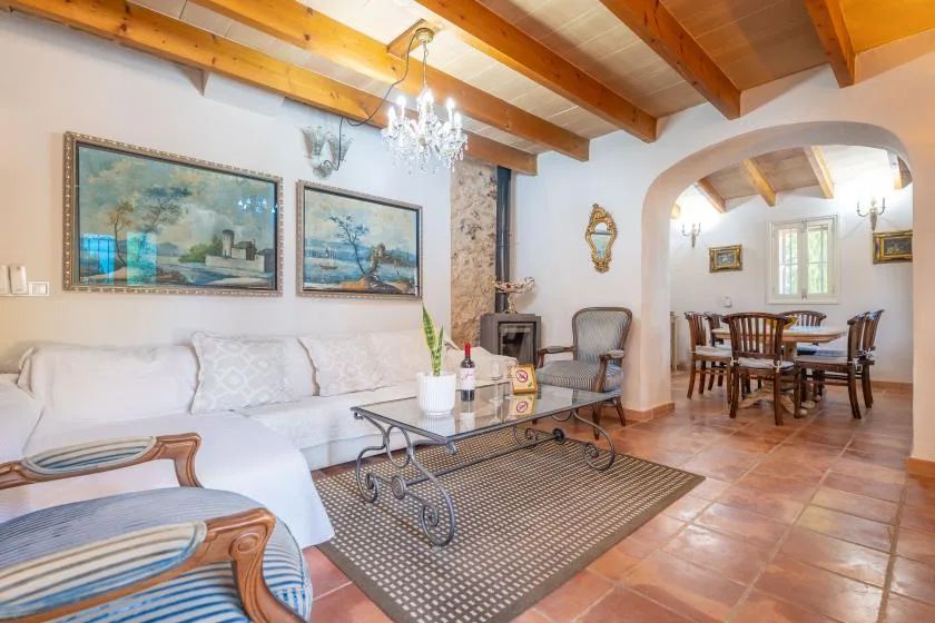 Una sala de estar con asientos, una mesa de centro y un arco que da al comedor.