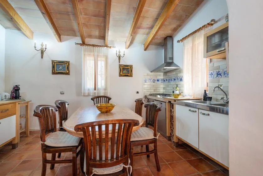 Una cocina y comedor con asientos de madera y una encimera.
